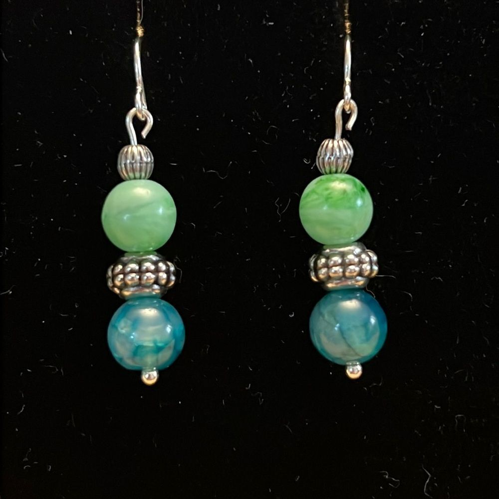 Handcrafted silver tone earrings with green and silver beading.